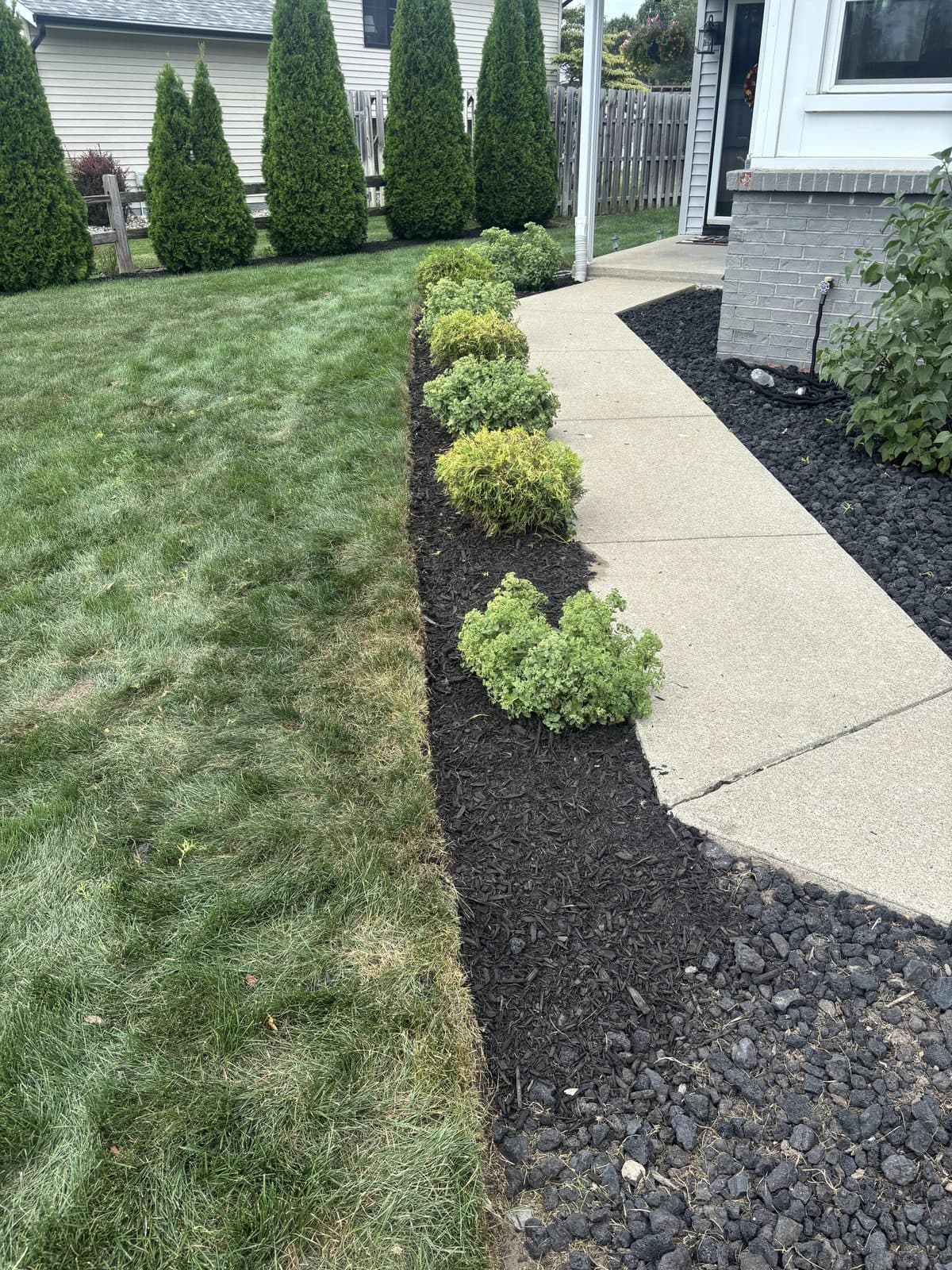 Freshly mulched and sharply edged landscape beds installed by Fresh Cut Lawns.