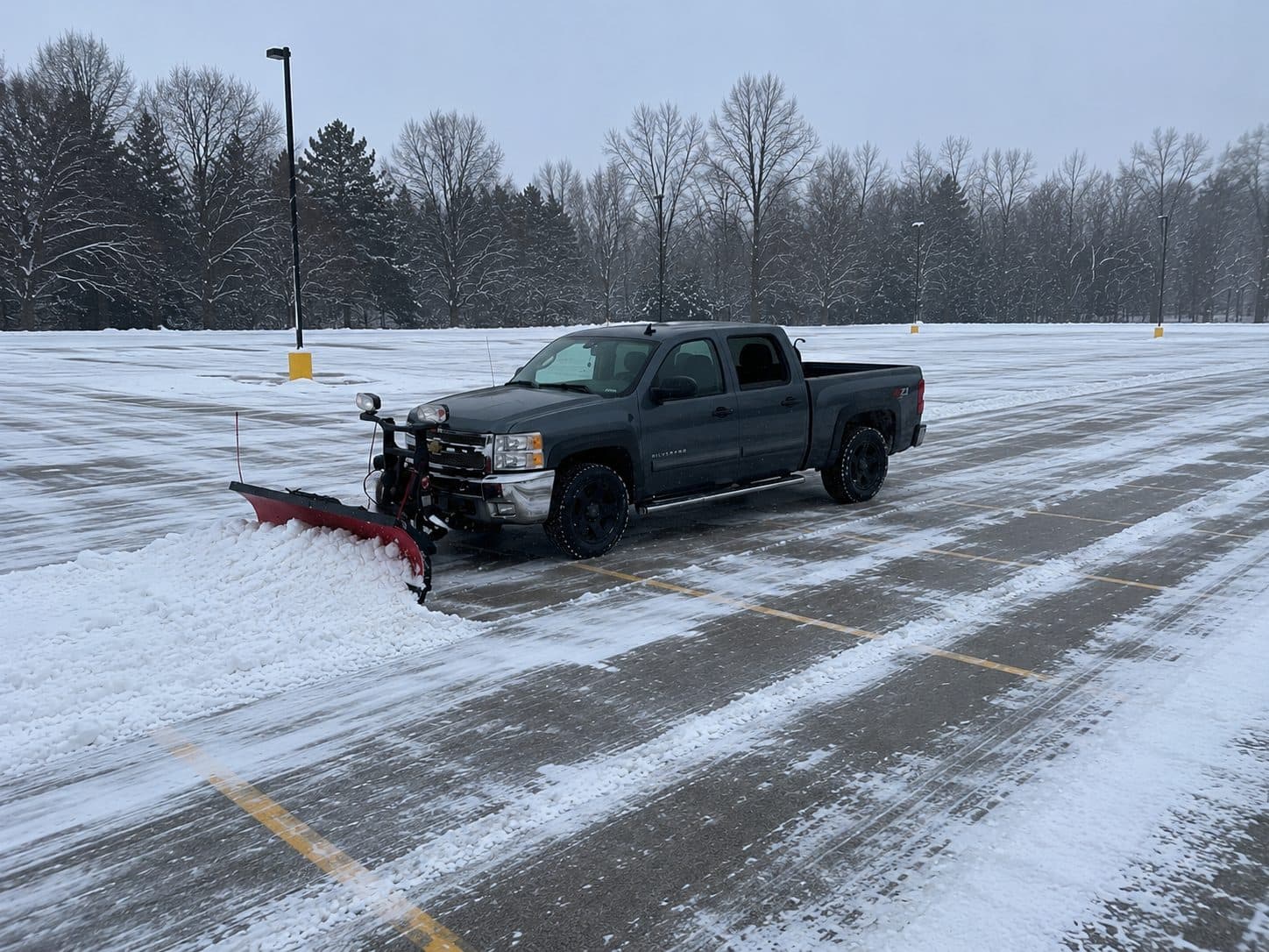 A Fresh Cut Lawns plow truck clearing snow from a residential driveway in winter.